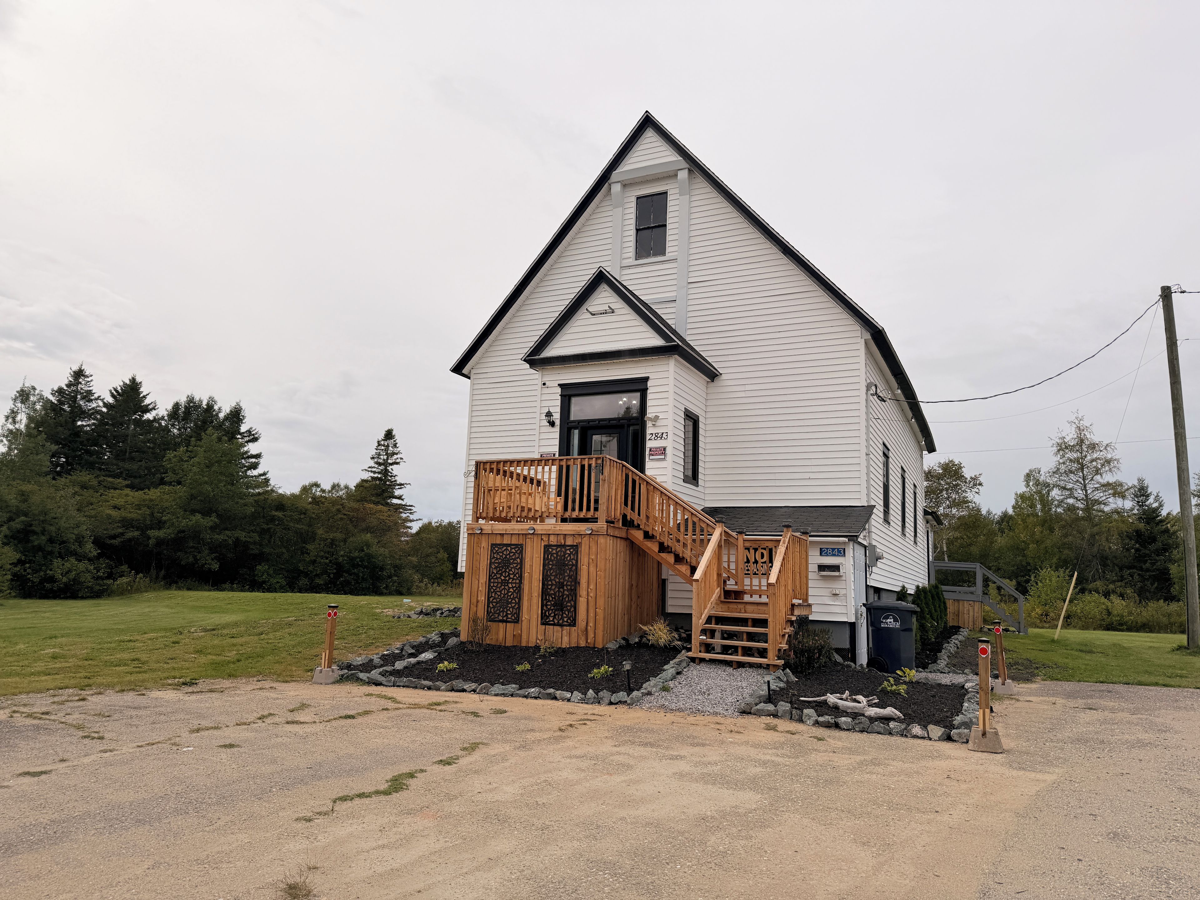 A two-story house with a wooden deck and a front porch.