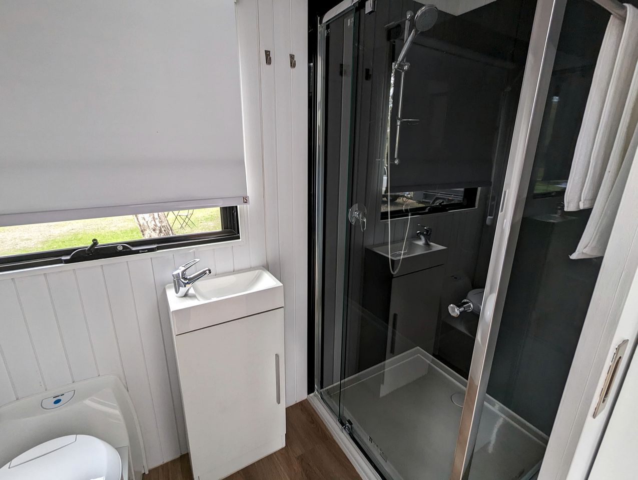 A compact bathroom with a shower, toilet, and sink.