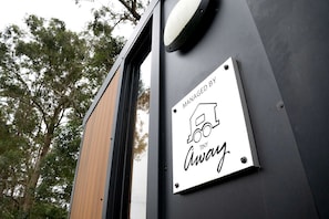 Un senyal a la paret d'un edifici amb una il·lustració d'un camió i el text 'MANAGED BY TINY Away'.