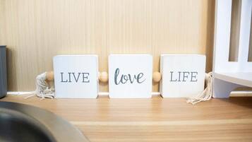 Tres bloques de madera con las palabras 'LIVE', 'love' y 'LIFE' sobre un estante de madera.