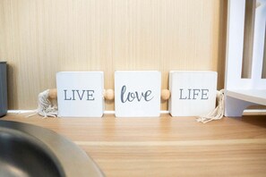 Three wooden blocks with the words 'LIVE,' 'love,' and 'LIFE' on a wooden shelf.
