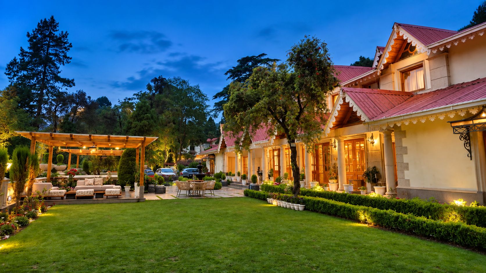 Un jardín bien cuidado con un patio, un mirador y un edificio con techo rojo.