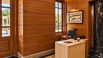 A reception desk with a computer, a framed picture on the wall, and a large window.