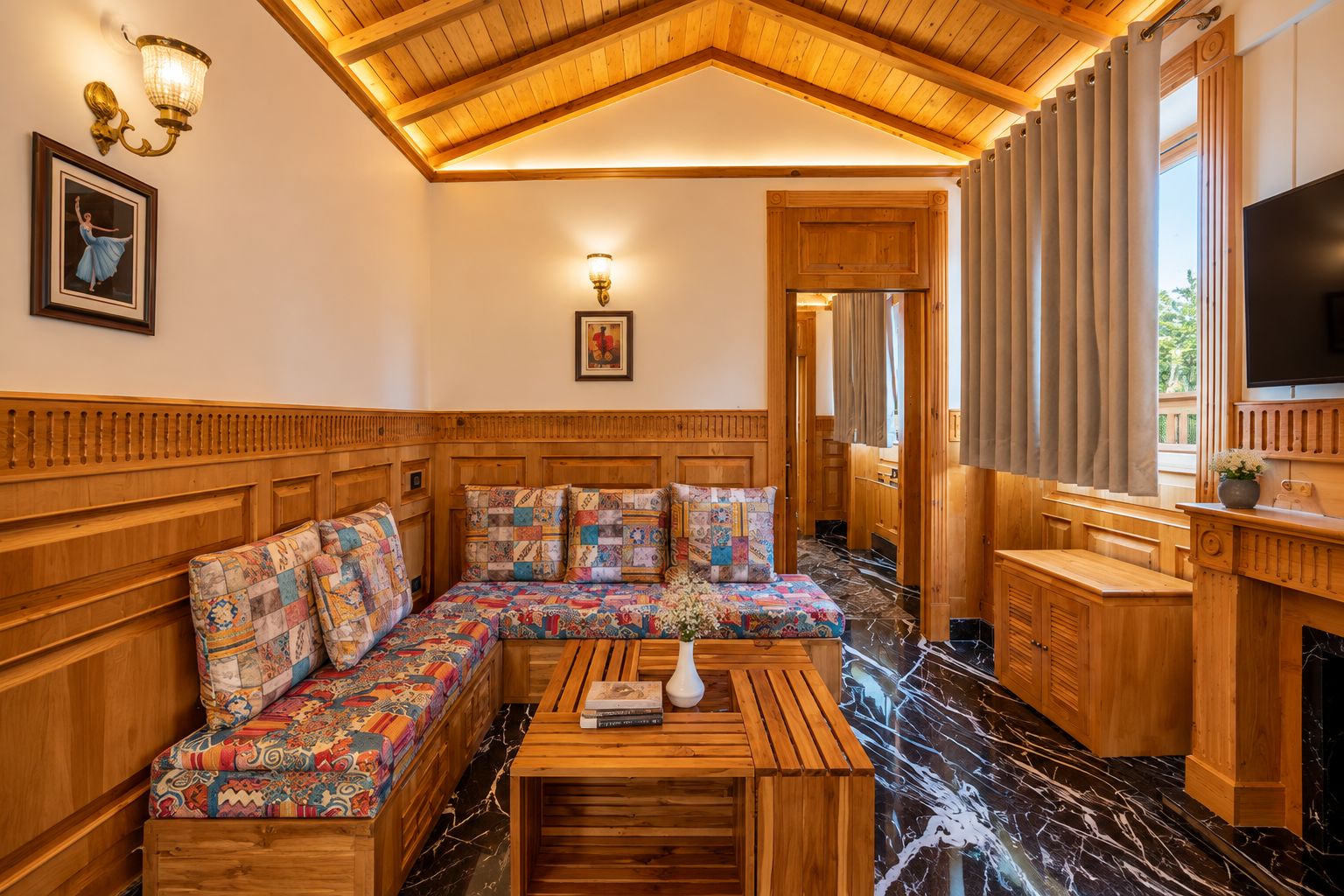 A cozy room with a wooden bench, a flat-screen TV, and a fireplace.