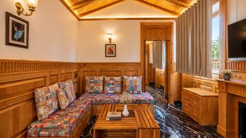 A cozy room with a wooden bench, a flat-screen TV, and a fireplace.