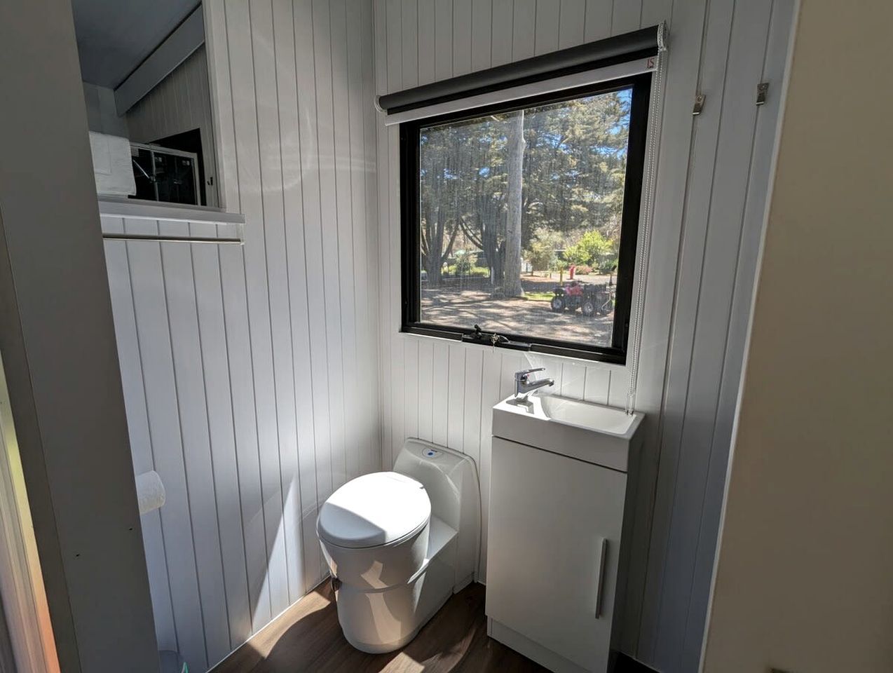A compact bathroom with a toilet, sink, and window.