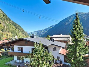Eine Berglodge mit Blick auf eine Seilbahnlinie, umgeben von bewaldeten Hügeln.