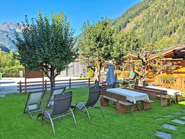 Eine Terrasse mit Sitzgelegenheiten im Freien und Blick auf ein Gebirge.