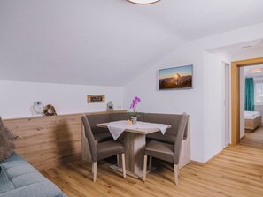 Ein gemütliches Zimmer mit einer Holzbank, einem kleinen Tisch und einem Bild an der Wand.