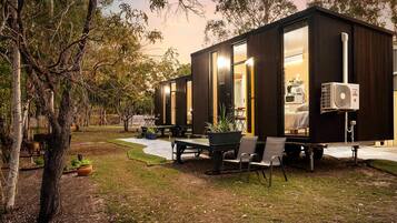 Una casa móvil moderna y compacta con ventanas amplias, comedor y terraza.