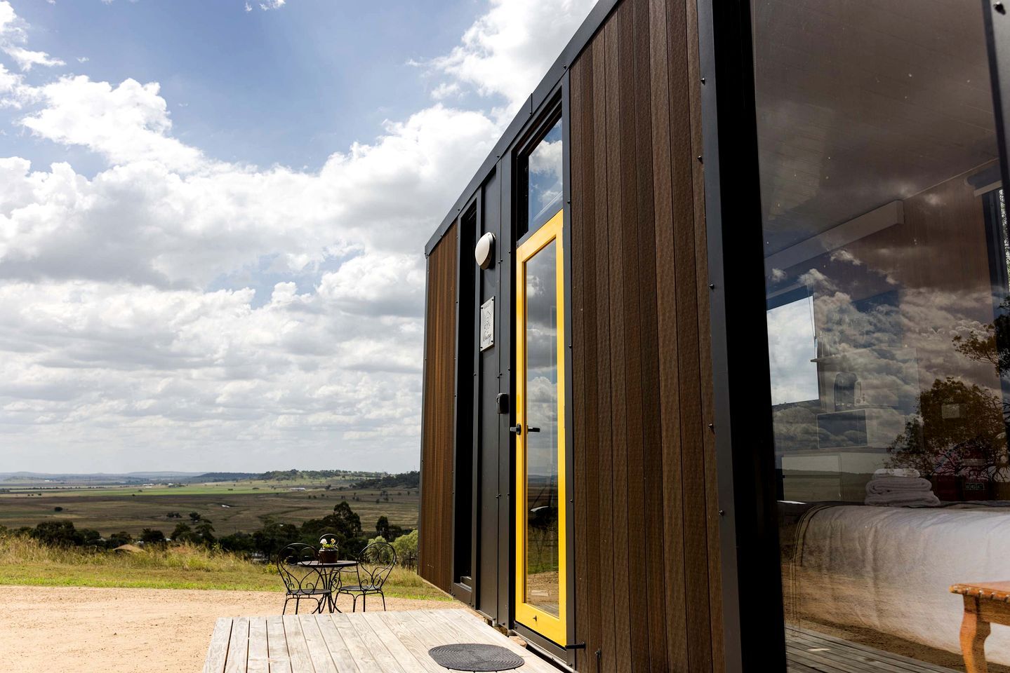 Un bâtiment moderne doté d’une grande porte vitrée et offrant une vue sur la campagne.