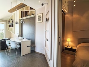 Ein modernes Schlafzimmer mit Bett, Nachttisch und Lampe.