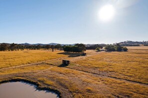 A rural landscape with a fenced area, a small structure, and a body of water. - Cozy Tiny House with Firepit Under Starry Skies in Maindample, Australia (Maindample)