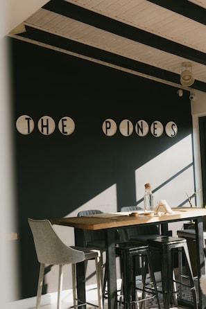 A dining area with a black wall, wooden ceiling, and a table with chairs. - THE PINES BOUTIQUE VILLA BRASOV (Brașov)