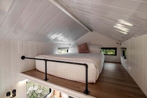 A bedroom with a bunk bed, a window, and a balcony.