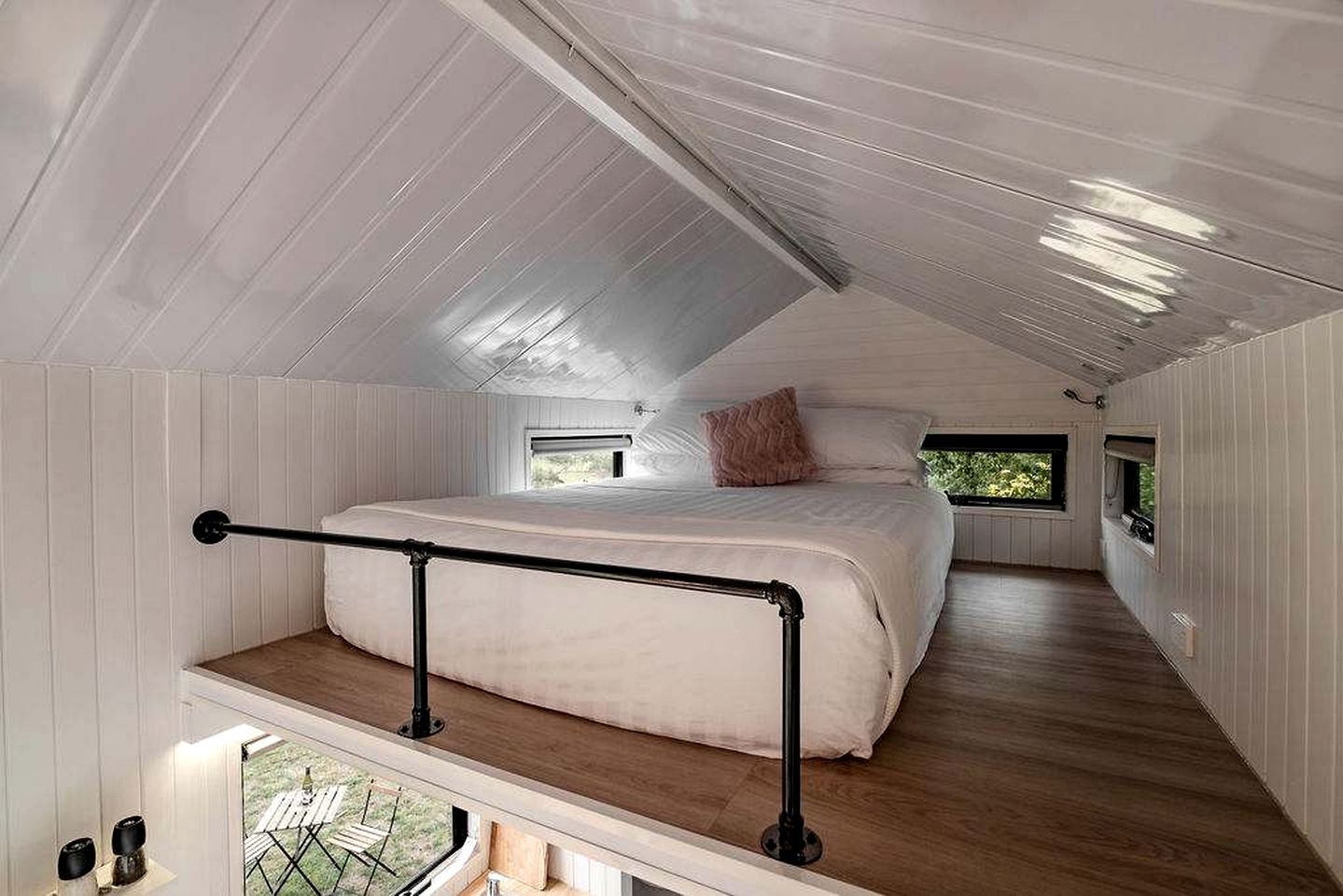 A bedroom with a bunk bed, a window, and a balcony.