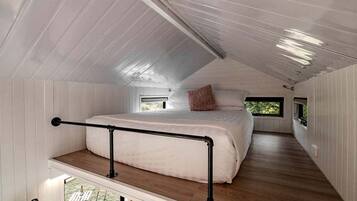 A bedroom with a bunk bed, a window, and a balcony.