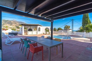 Eine Außenpatio mit Pool, Sitzgelegenheiten und einer Pergola.