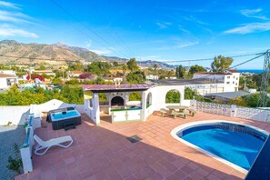 Ein Wohnhaus mit Swimmingpool, Sitzgelegenheiten im Freien und Blick auf die umliegende Landschaft.