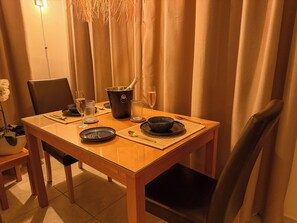 A dining table set with plates, cutlery, glasses, and a champagne bucket. - Sabai Pafos | Stylish Poolside Apartment with Sea View & Two Sunny Terraces (Pafos)