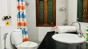 A bathroom with a toilet, sink, shower, and a mirror. - Cotyard Banquet & Wedding Venue Delhi (New Delhi)