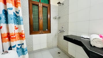 A bathroom with a shower, a toilet, and a sink.