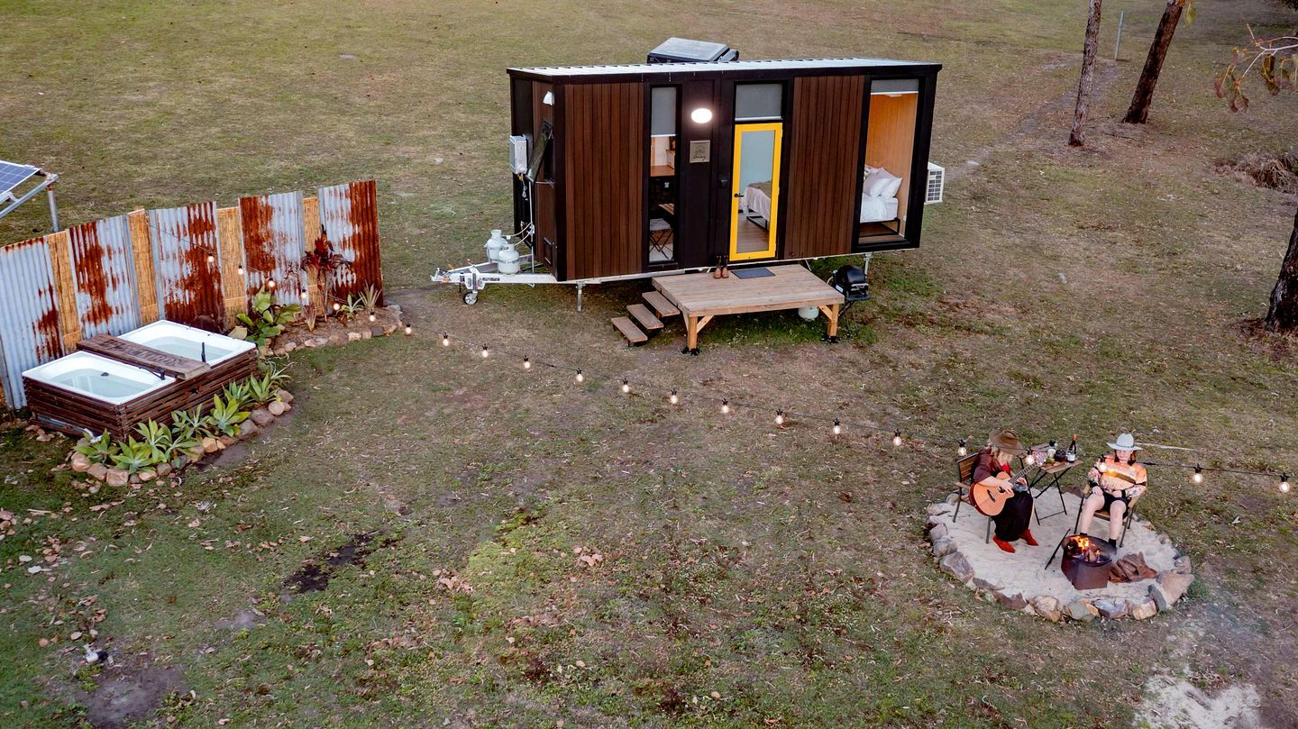 A small, single-story cabin with a visible bedroom and a patio area.