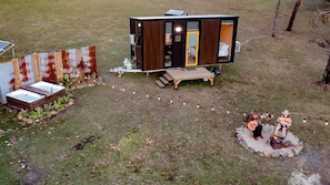 A small, single-story cabin with a visible bedroom and a patio area.