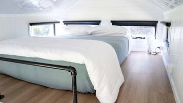 Une chambre à coucher avec un lit, une fenêtre et une vue sur l’extérieur.