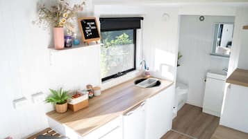 Eine kleine Küche mit einer Holz Arbeitsplatte, einem Kreidetafel-Schild und einem Fenster mit Blick.