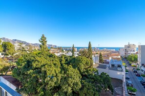A coastal cityscape with dense greenery, buildings, and a clear blue sky. - Holiday Home in Nerja With Sea Views (Nerja)