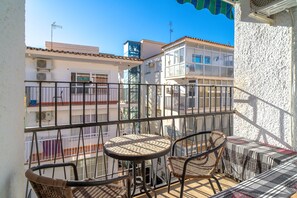 A balcony with a table and chairs, overlooking a residential area with buildings. - Holiday Home in Nerja With Sea Views (Nerja)