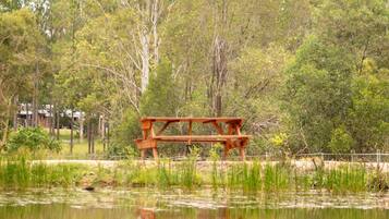A picnic table in a natural setting with trees and a body of water.