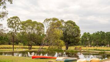 A serene lakeside setting with picnic tables and boats.