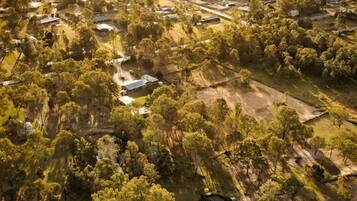 An aerial view of a residential area with houses, roads, and surrounding greenery.
