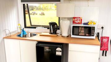 A compact kitchen with a sink, a microwave, and a coffee maker.