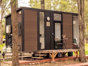 Una petita cabana amb una porta corredissa, una finestra i una taula amb caires a l'exterior.