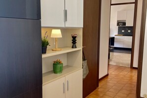 A modern kitchen with white cabinets, a microwave, and a wooden countertop. - Bnbook Balzarotti 10 (Rho)