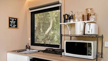 Une petite cuisine équipée avec une fenêtre, un évier, un four à micro-ondes et un lave-vaisselle.