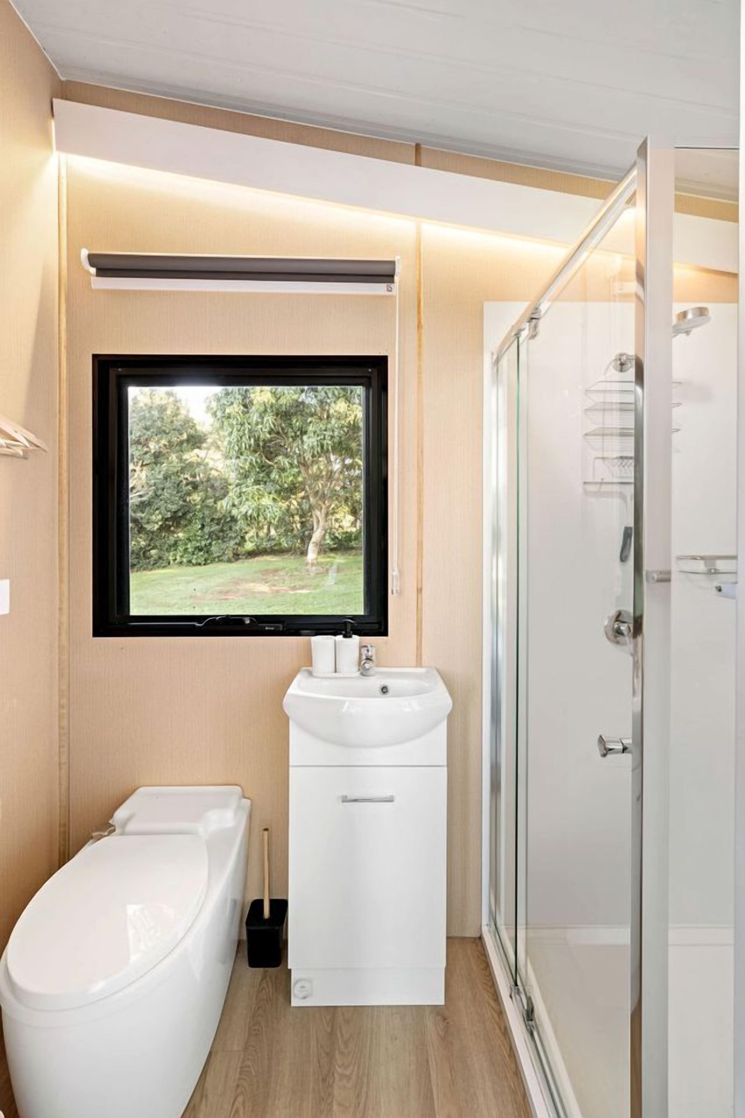 Une salle de bain moderne équipée de toilettes, d’un lavabo et d’une douche.
