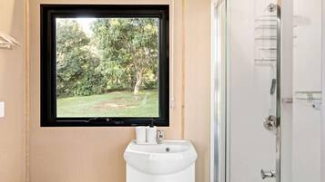 Une salle de bain moderne équipée de toilettes, d’un lavabo et d’une douche.