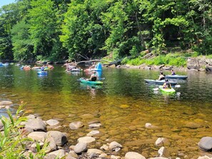 A river with clear water, surrounded by rocks and greenery.