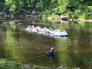 Un grupo de personas en balsas inflables en un río rodeado de vegetación.