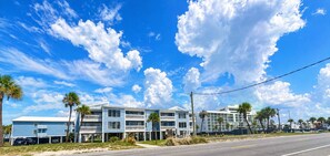A coastal building with multiple balconies and a clear sky. - Barefoot Hideaway | Beach + Pool + Boat Friendly + Lagoon | Sea Oats (Gulf Shores)
