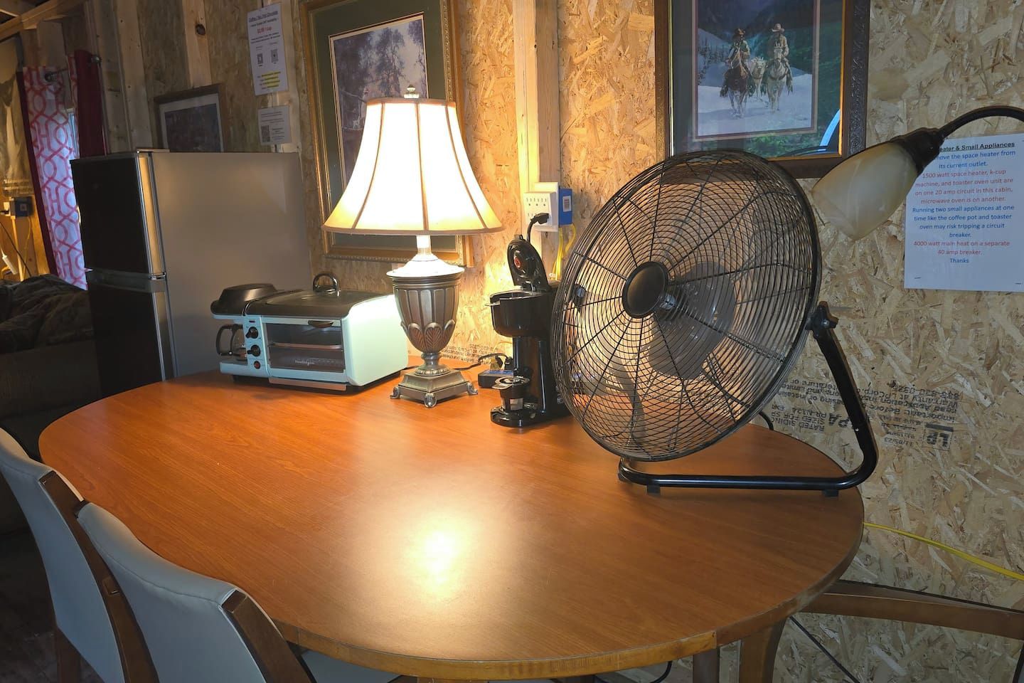 Ein Holztisch mit einer Lampe, einem Ventilator und einem Vintage-Radio.