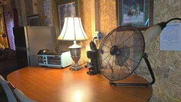 Ein Holztisch mit einer Lampe, einem Ventilator und einem Vintage-Radio.