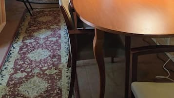 Une pièce comprenant une table à manger en bois, un canapé, une lampe et un escalier.