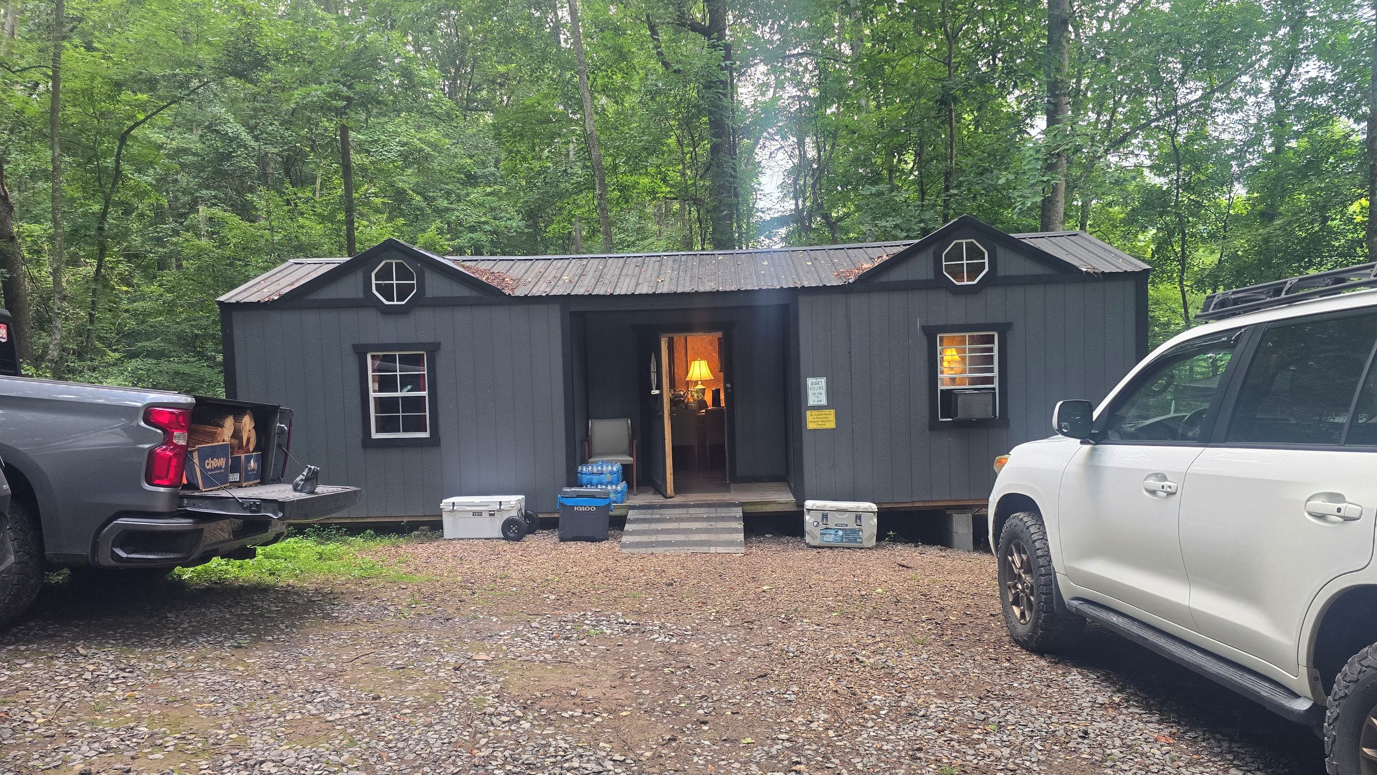 Une petite cabane avec une porte d’entrée, des fenêtres et un panneau indiquant les heures de silence.