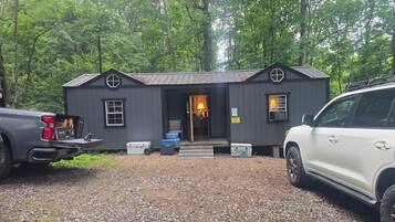 Une petite cabane avec une porte d’entrée, des fenêtres et un panneau indiquant les heures de silence.