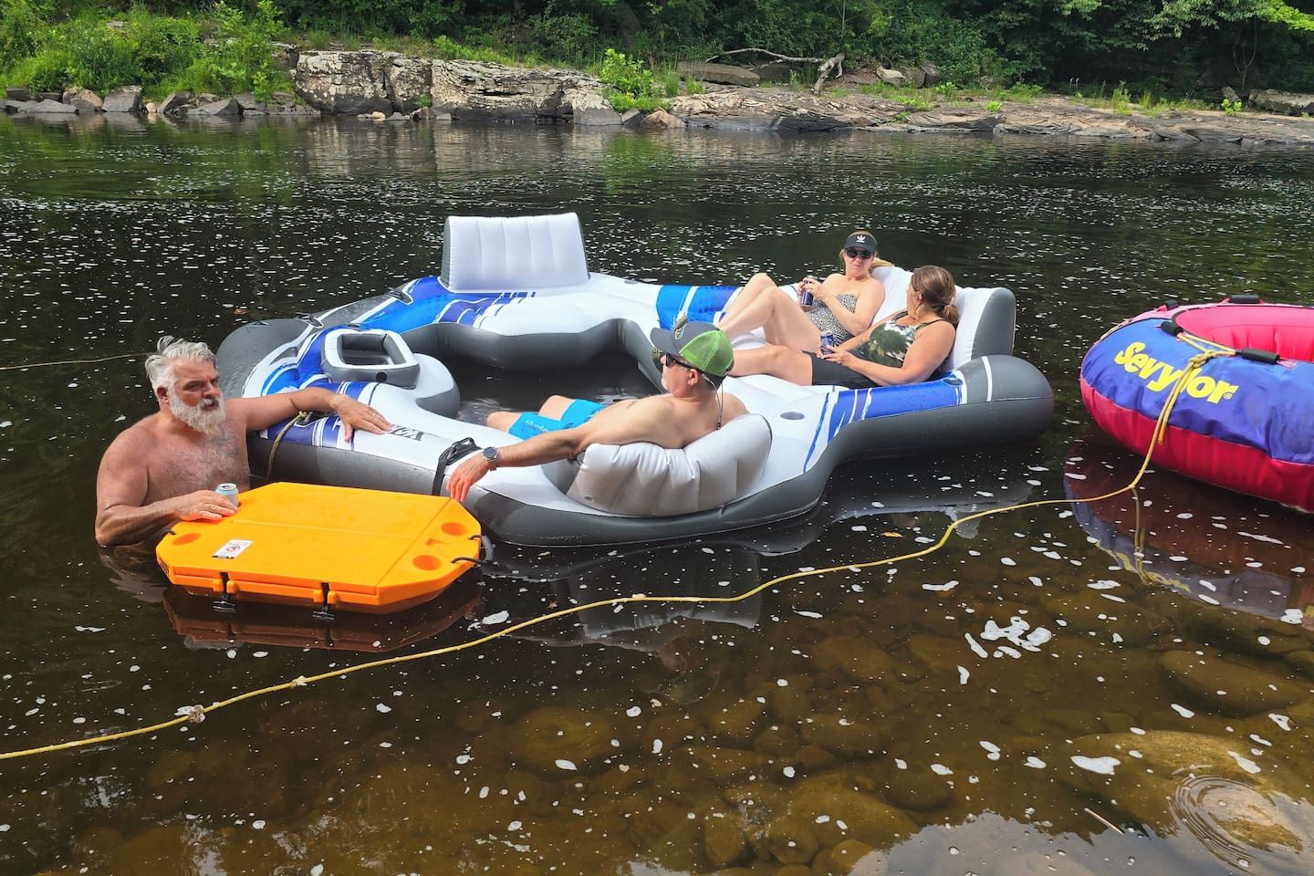 People floating on inflatable rafts in a body of water.